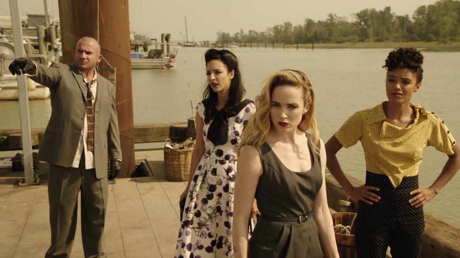 Zari, Sara, and Charlie look to where Mick is pointing across the dock.