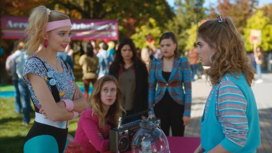 Mel and Maggie watch as Jenna Gordonson tells off Brenda at the Kappa fundraising table.