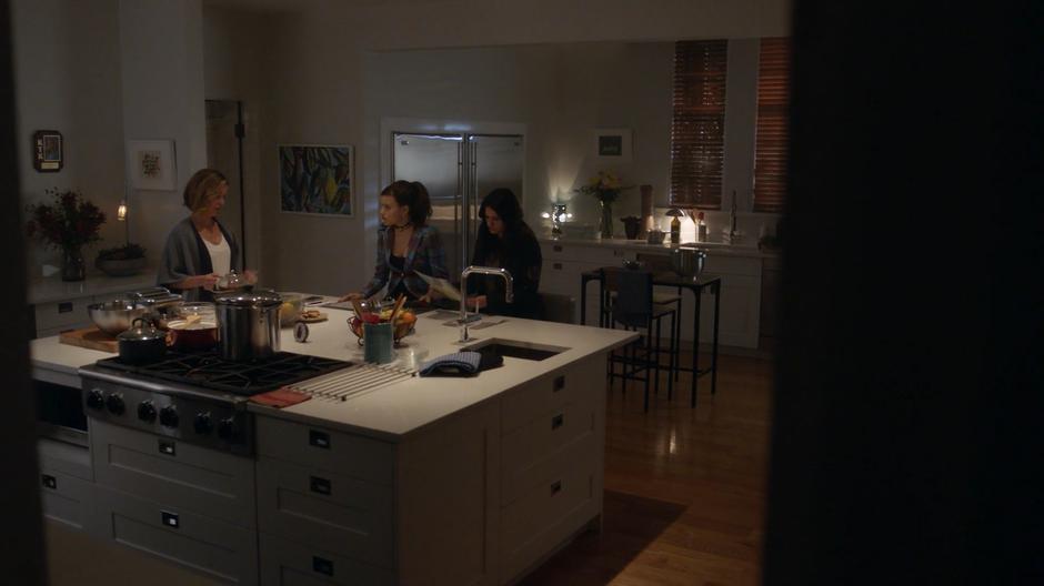 Jenna Gordonson prepares tea while Maggie and Mel look over the news clippings she has compiled over the years.