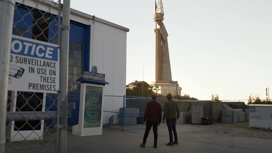 James and Tom look up at the monument rising over the island.