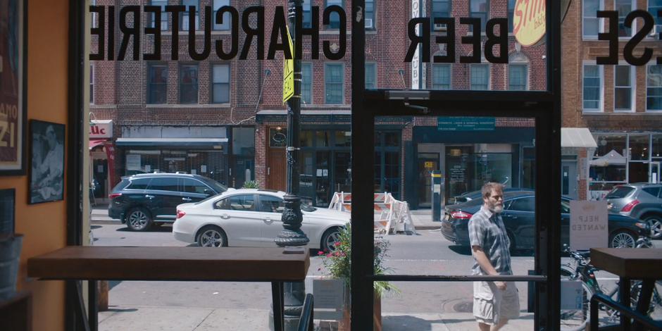 Frank notices the help wanted sign in the window as he is walking past.