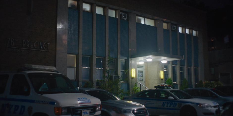 Establishing shot of the front of the police station at night.
