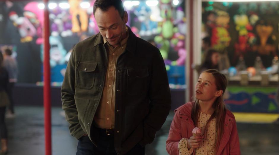 Grace walks next to Orlin while eating an ice cream cone.