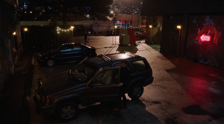 A man gets into his car after saying goodbye to his date.