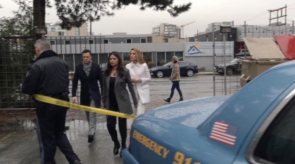 Harry, Mel, and Charity walk up to the police line that is being run by an officer.