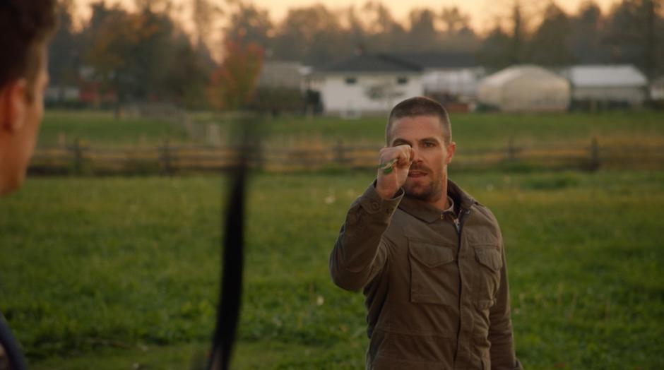 Oliver catches an arrow fired by Barry with his new speed.