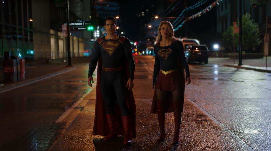 Clark and Kara stand in the street waiting to stop Amazo as it runs past.