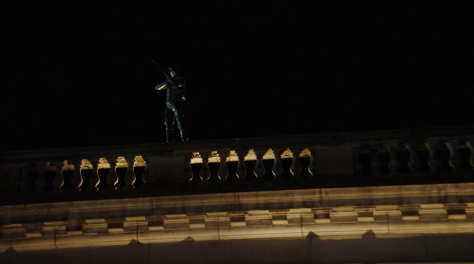 Barry stands on the rooftop and prepares to fire an arrow at Amazo.