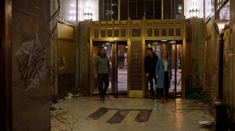 Oliver, Barry, and Kara enter the lobby of the abandoned building.