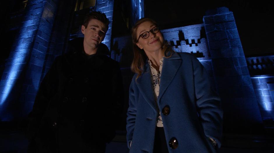 Barry and Kara watch Oliver as he does his tech stuff.