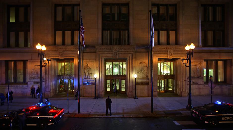 Kara and the others exit the police station while a man in a suit waits out front.