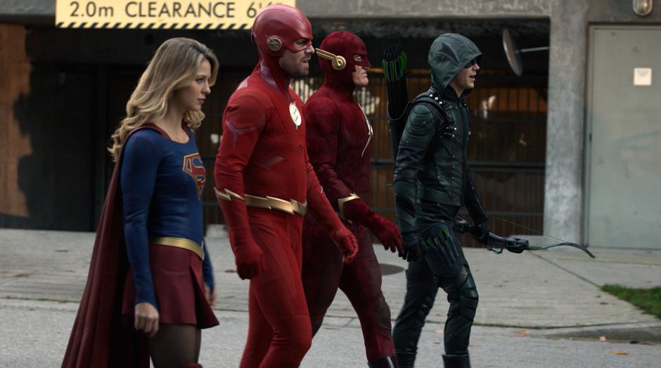 Kara, Oliver, Earth-90 Flash, and Barry walk down the street towards the Monitor.