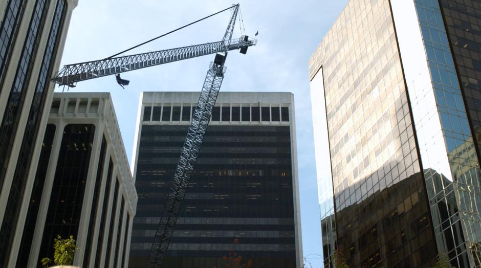 Superman catches the crane before it can collapse.