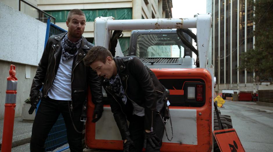 Oliver and Barry catch their breath while hiding behind some construction equipment.