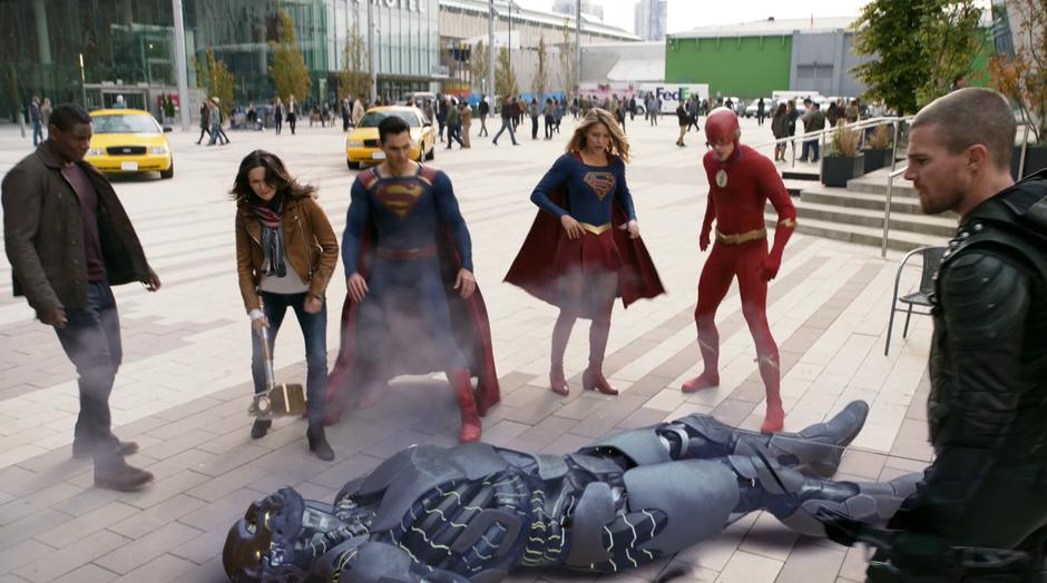 J'onn, Lois, Clark, Kara, Barry, and Olvier jump back as a defeated Amazo crashes to the ground between them.