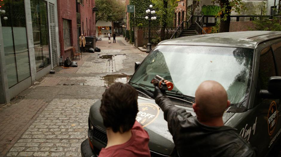 Ray and Mick point their guns down the alley at the present-day Constantine while his past self talks with Desmond farther down the alley.