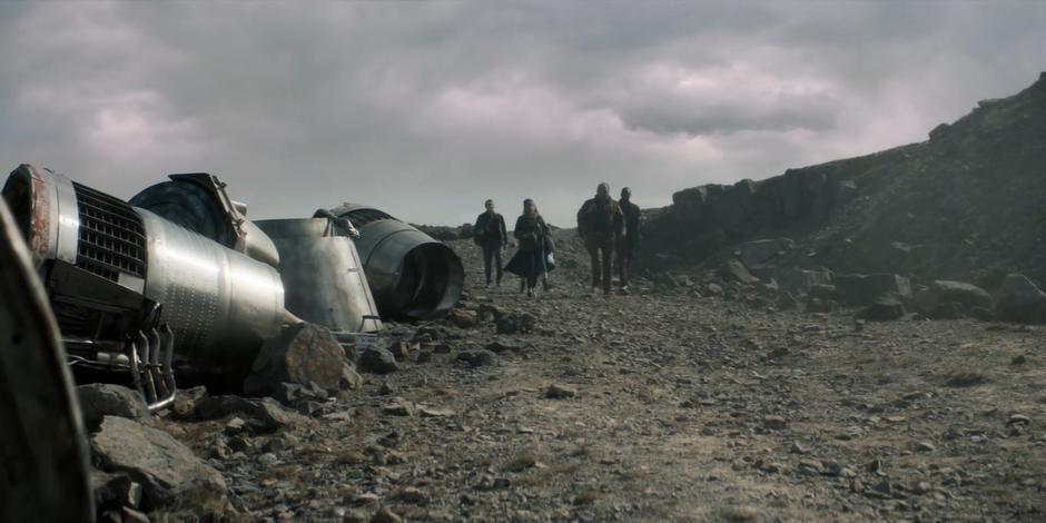 Graham, Yaz, the Doctor, Paltraki, and Ryan walk through the ship graveyard.