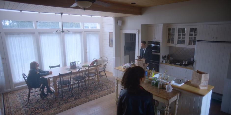 Marcy, Grant, and Carly talk in the kitchen.