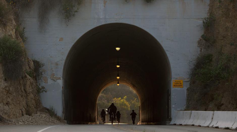 The teens ride down the tunnel on their stolen bikes.