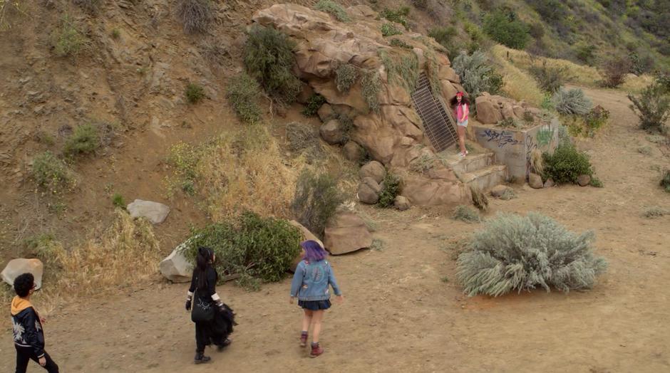 Alex, Nico, and Gert approach while Molly stands by the sealed gate.