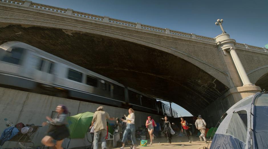 Gert, Karolina, Molly, Nico, and Alex run out from under the bridge towards the explosions that woke them.