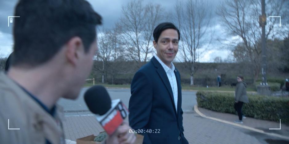 A reporter films and questions Daniel Sosa as he is walking back to his car.