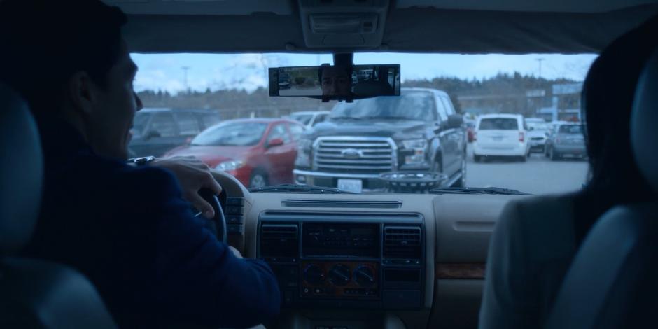 Daniel Sosa looks in the rear-view mirror as a truck stops behind his car.