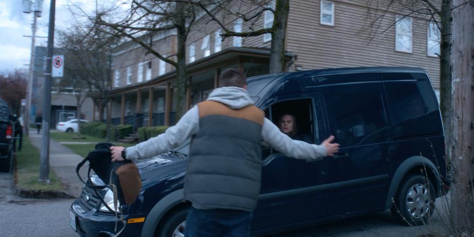 Trevor walks over to Philip who is pulling up in the alley.