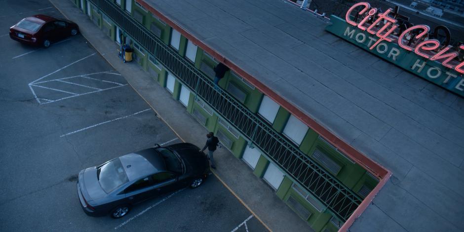 Jeff puts his hand against the hood of his car for support while stumbling drunkenly around it.