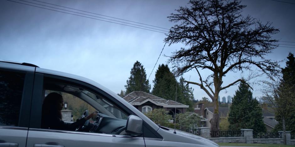 Carly drives her car away from the house.