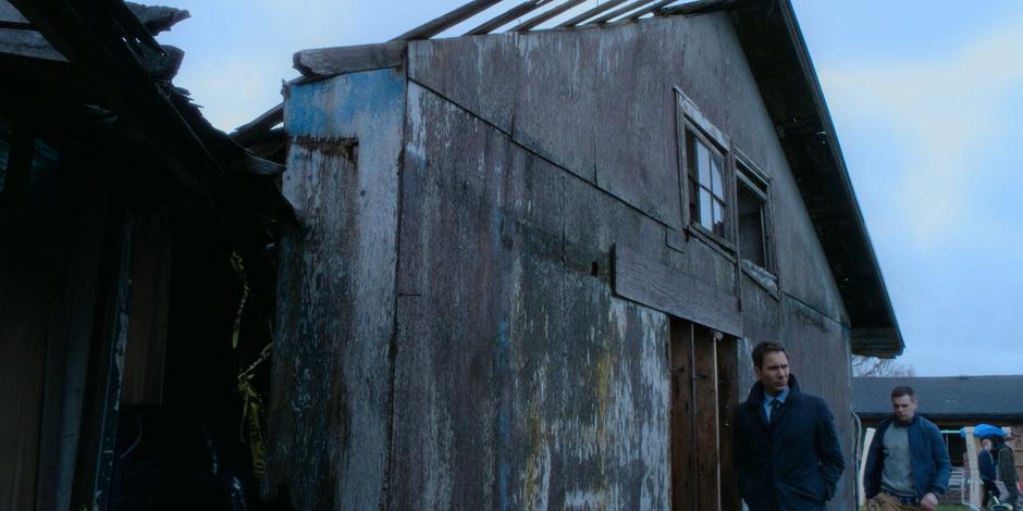 Grant and Aleksander walk around the rundown building at the back of the property looking for Aleksander.