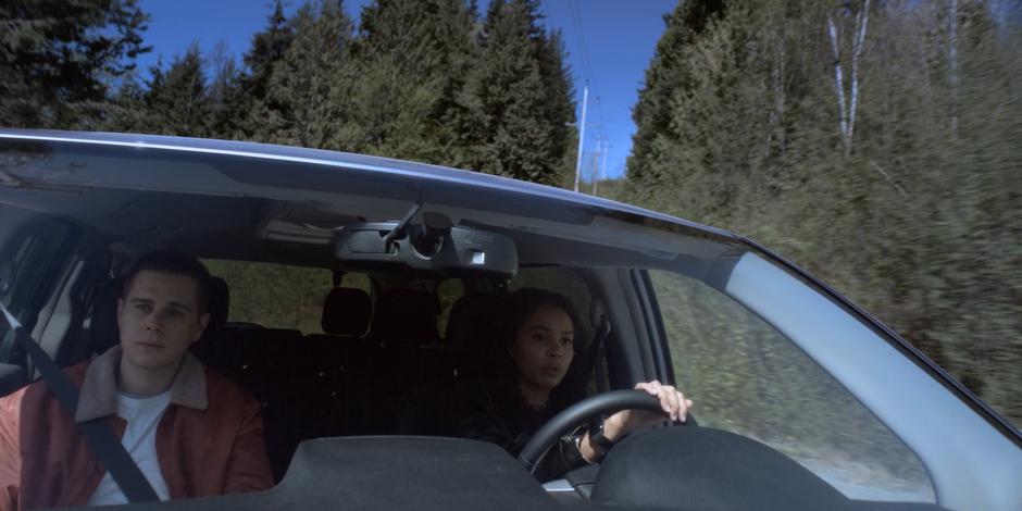 Trevor and Carly drive down a winding road.