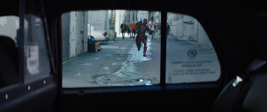 Wade runs down the alley towards the waiting cab while being chased by a bunch of dudes.