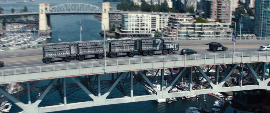 The convoy truck drives across the bridge into downtown.