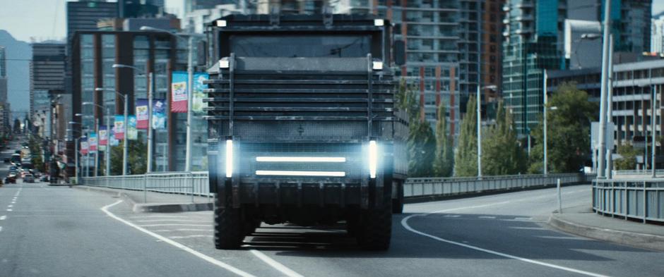 The convoy truck turns back onto the bridge heading out of downtown.