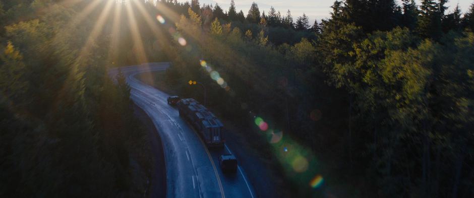 The convoy drives down a winding road from the mountains.