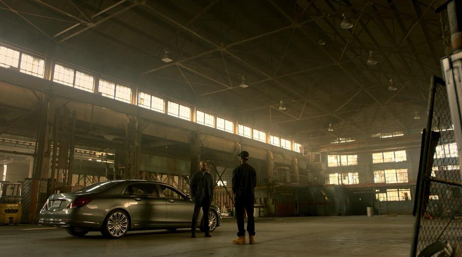 Geoffrey and Darius talk next to his car while Alex sits inside.