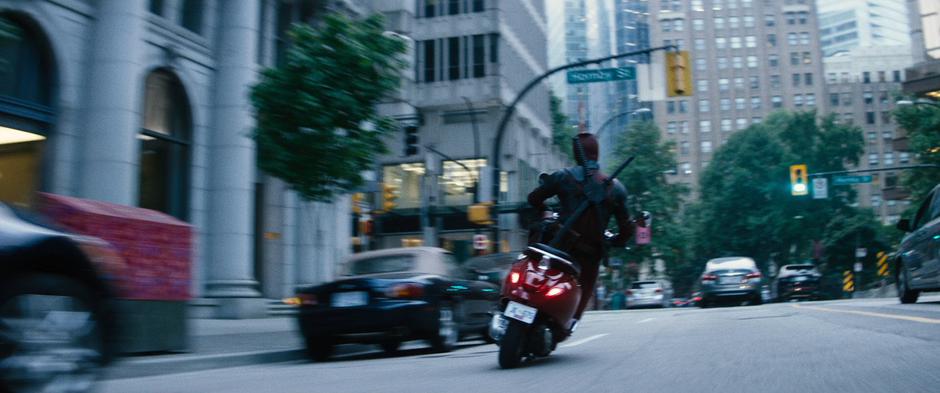 Wade drives down the street on his stolen scooter.