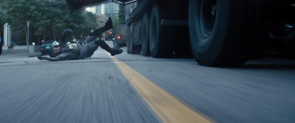 A guard falls from the side of the truck after being thrown by Domino.