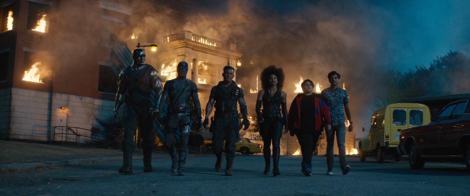 Colossus, Wade, Cable, Domino, Russell, and Dopinder walk away from the burning building.