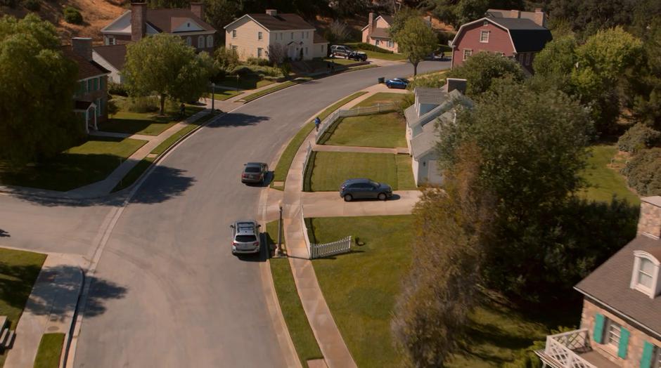 Establishing shot of the clean suburb as a person walks down the sidewalk.