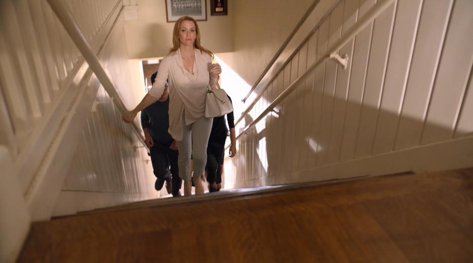 Leslie leads the parents up the stairs to the second floor offices.