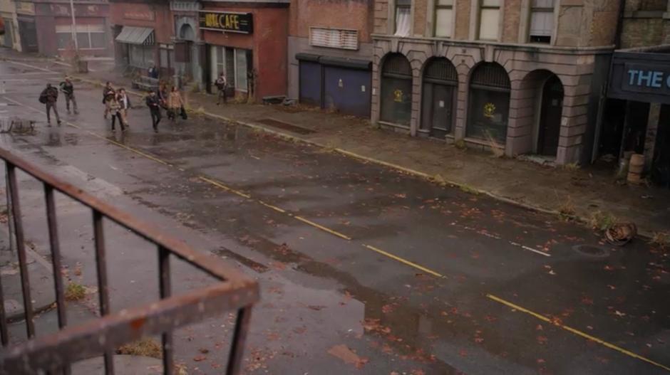 The supply party walks down a large abandoned street.