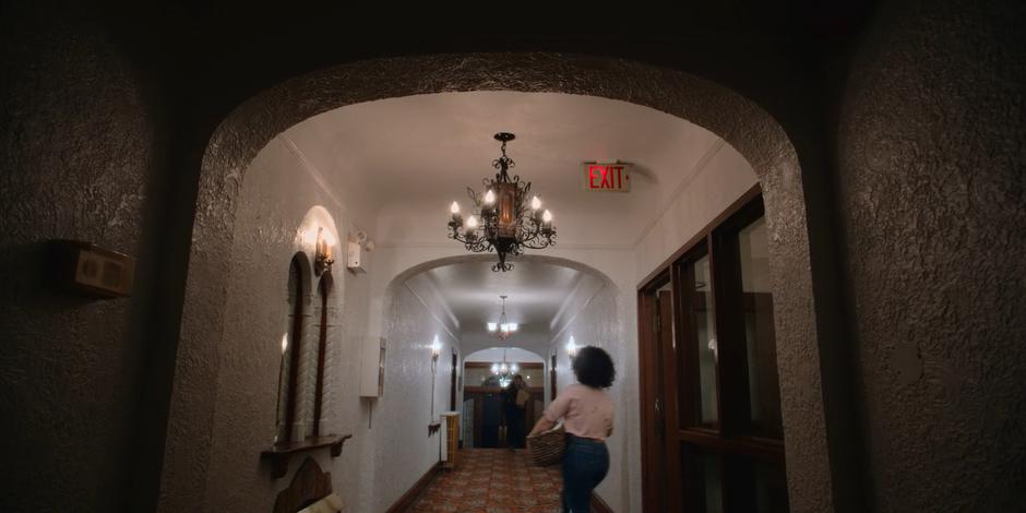 Jessica Moore walks down the hallway with her laundry as Carly is arriving with groceries.