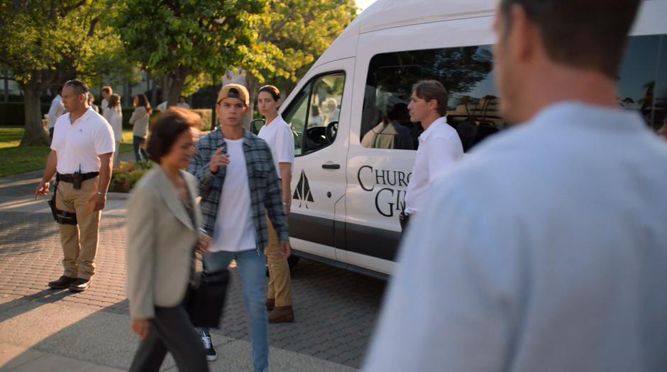 Oscar points his finger at Frank as he walks past the church van.