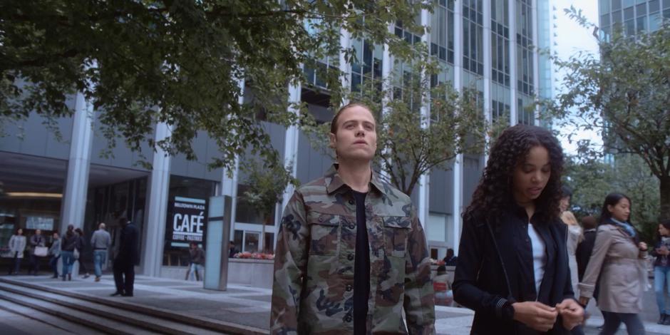 Philip looks down the block while Carly answers his question about coffee.