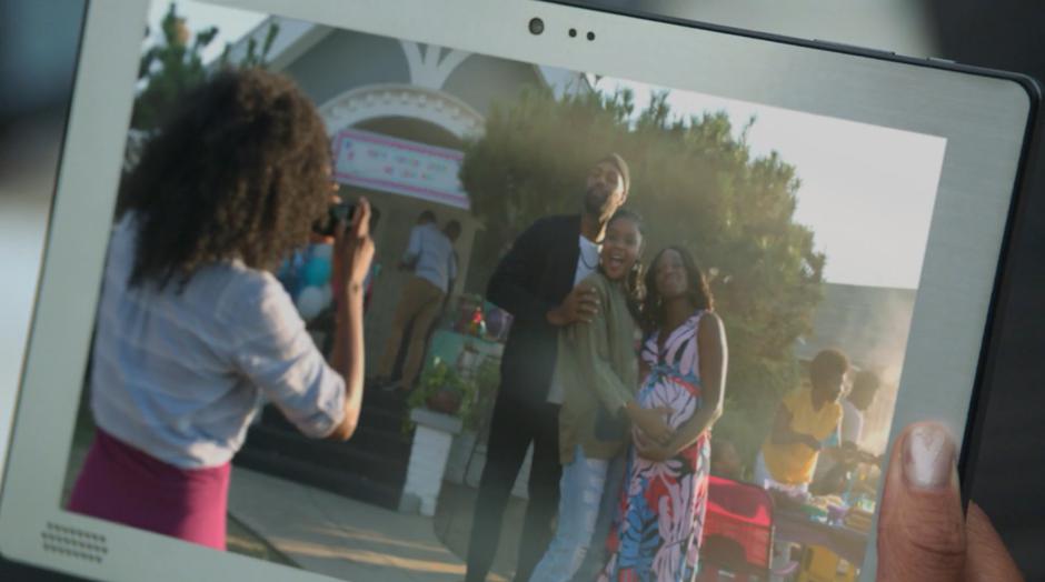 Darius, Livvie, and Tamar pose for a photo in front of the house during a BBQ.