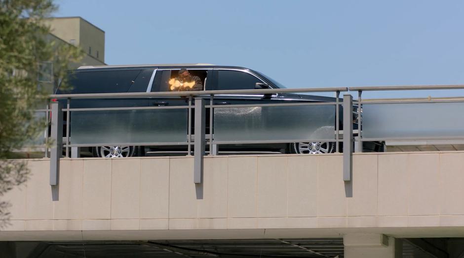 AWOL fires down at Livvie from the window of a SUV as it drives past on the upper floor of the parking garage.