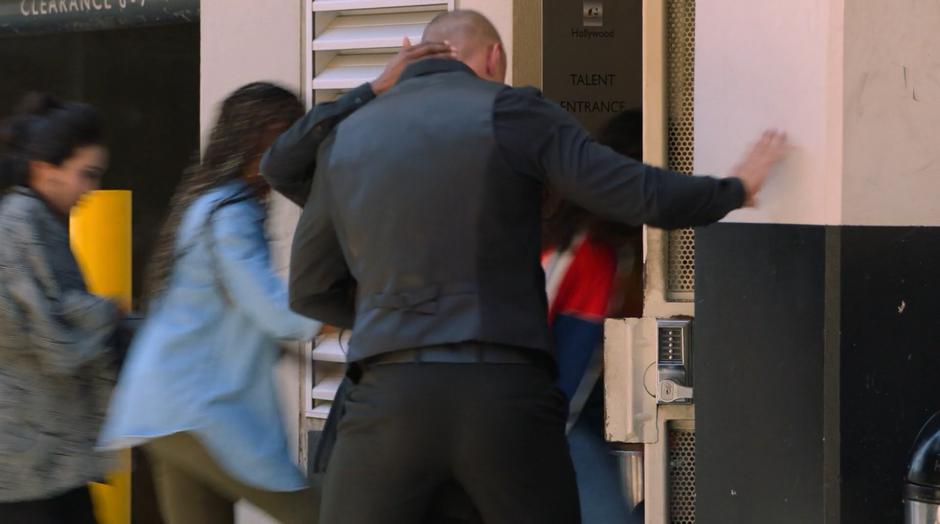 Nico, Livv, and Molly sneak in through the service entrance while two employees are distractedly making out.