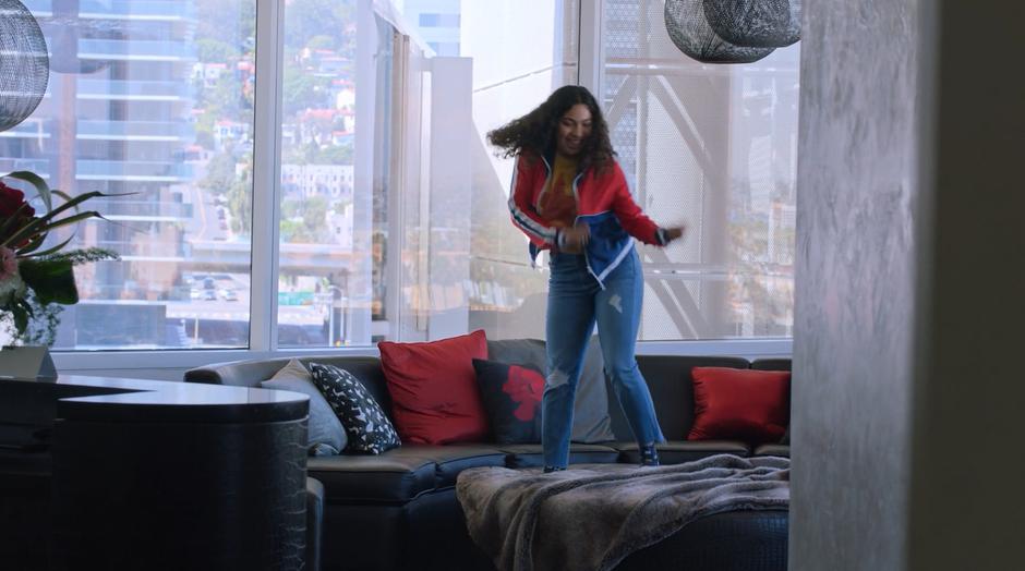 Molly dances on the couch in the main room.